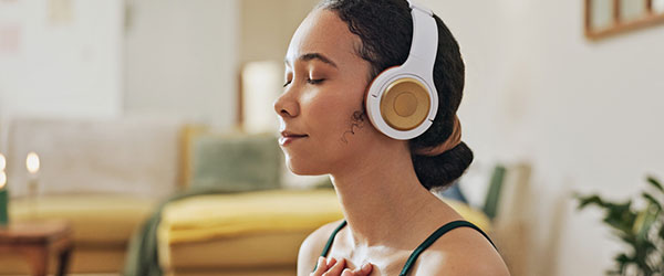 woman sitting and meditating with headphones on